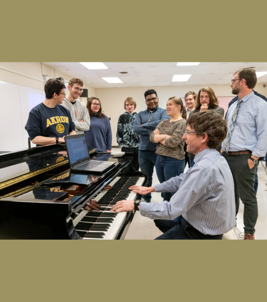 Students learning around a piano.